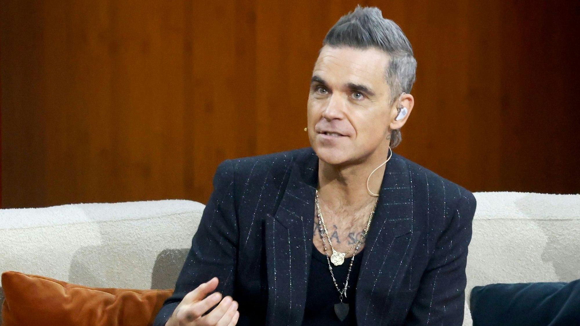 Robbie Williams blickt an der Kamera vorbei.