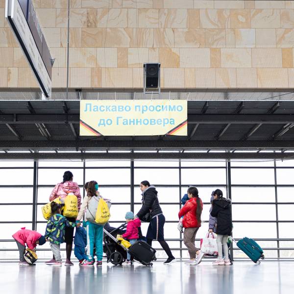 Geflüchtete aus der Ukraine gehen durch die Eingangshalle vom Messebahnhof Laatzen.