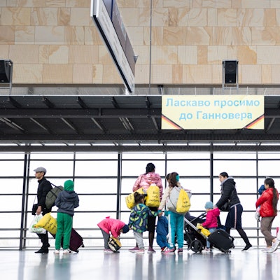 Geflüchtete aus der Ukraine gehen durch die Eingangshalle vom Messebahnhof Laatzen.