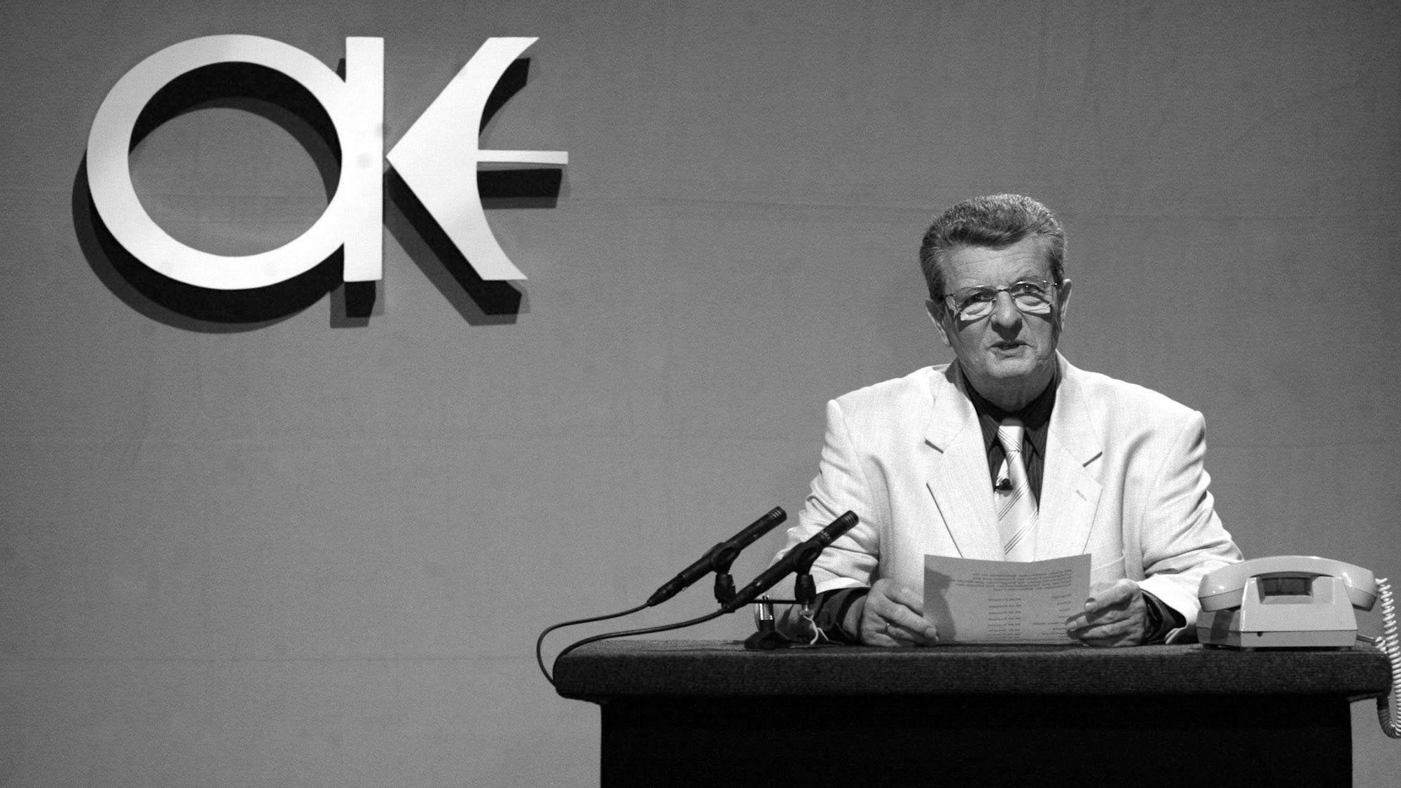 ARCHIV - 18.09.2003, Sachsen, Leipzig: Klaus Feldmann, Sprecher der ehemaligen DDR-Nachrichtensendung «Aktuelle Kamera», sitzt während einer Aufzeichnung für die vierte Folge der Ostalgieshow «Ein Kessel DDR» des Mitteldeutschen Rundfunks an einem Nachbau seines alten Arbeitsplatzes.