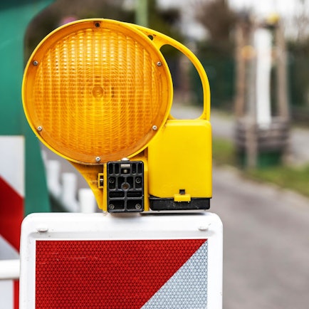 Eine Warnleuchte an einer Baustelle auf der Straße ist abgebildet.