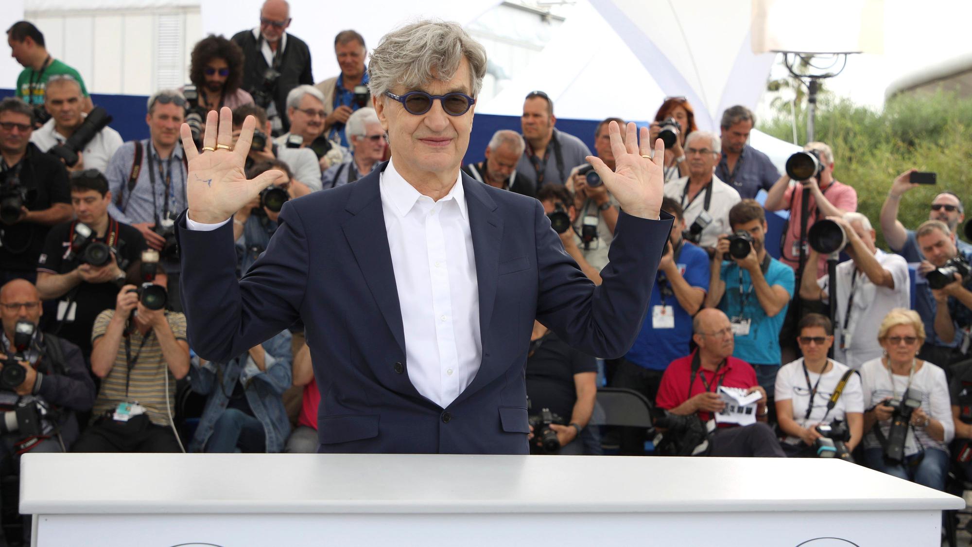 Wim Wenders kommt zum Fototermin im Rahmen des 71. Filmfestivals in Cannes. Er winkt der Menge zu.