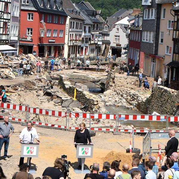 Das Bild aus den Tagen nach der Flutkatastrophe in Bad Münstereifel zeigt die damalige Bundeskanzlerin Angela Merkel und den damaligen NRW-Ministerpräsidenten Armin Laschet an Rednerpulten.