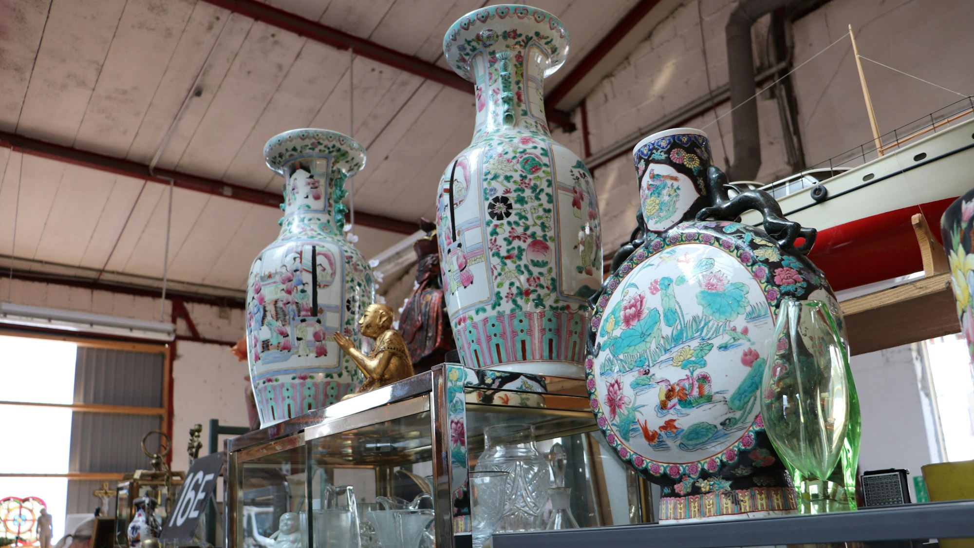 Bunte Vasen stehen auf einem Regal.