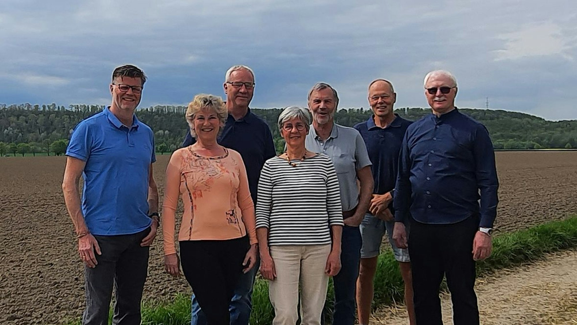 Mitglieder der Initiative „Glessen autark“ vor einem Feld, auf dem ein Windkraftprojekt realisiert werden soll.