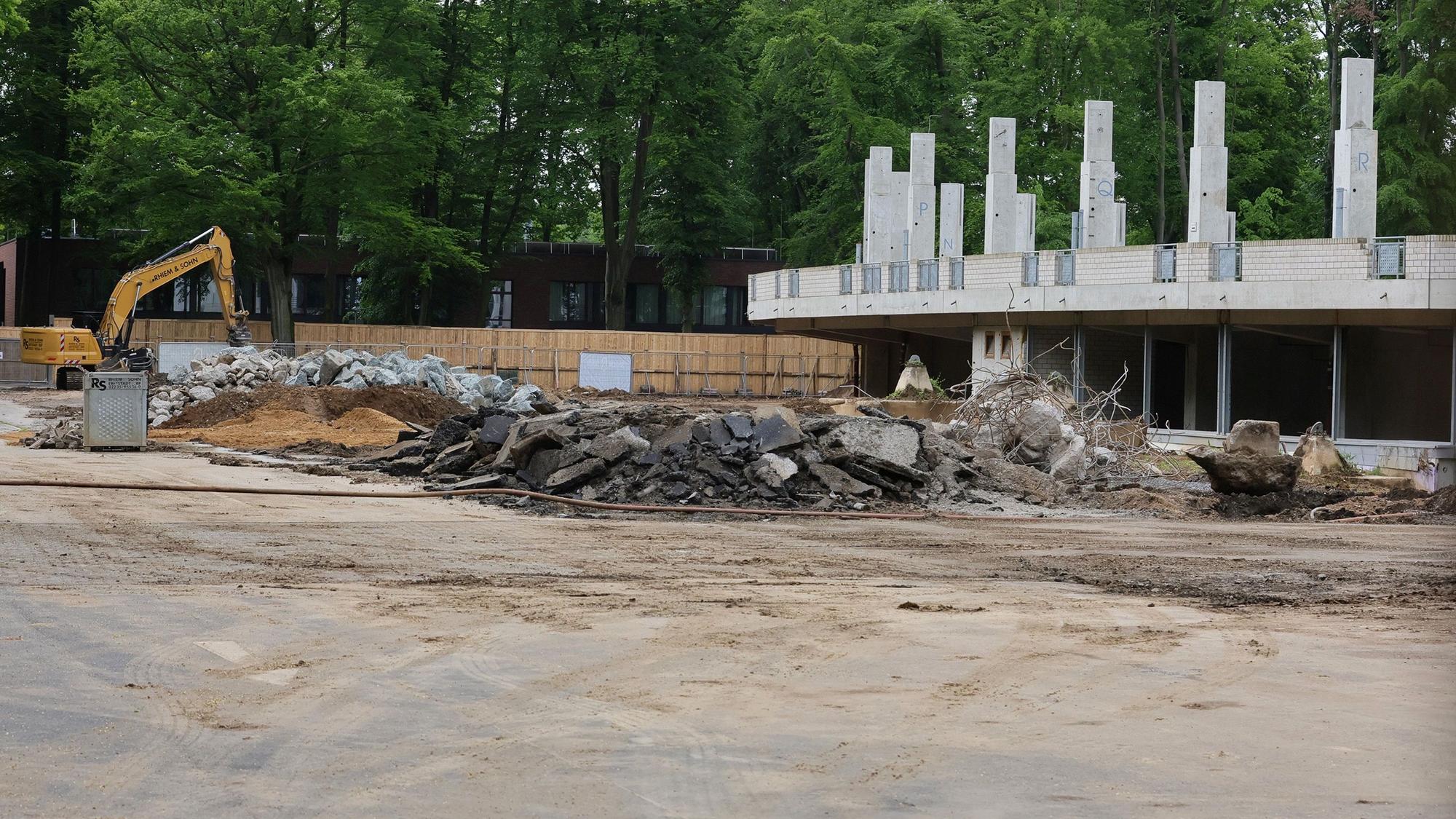 Das Bild zeigt einen Bagger und Reste der Radrennbahn.