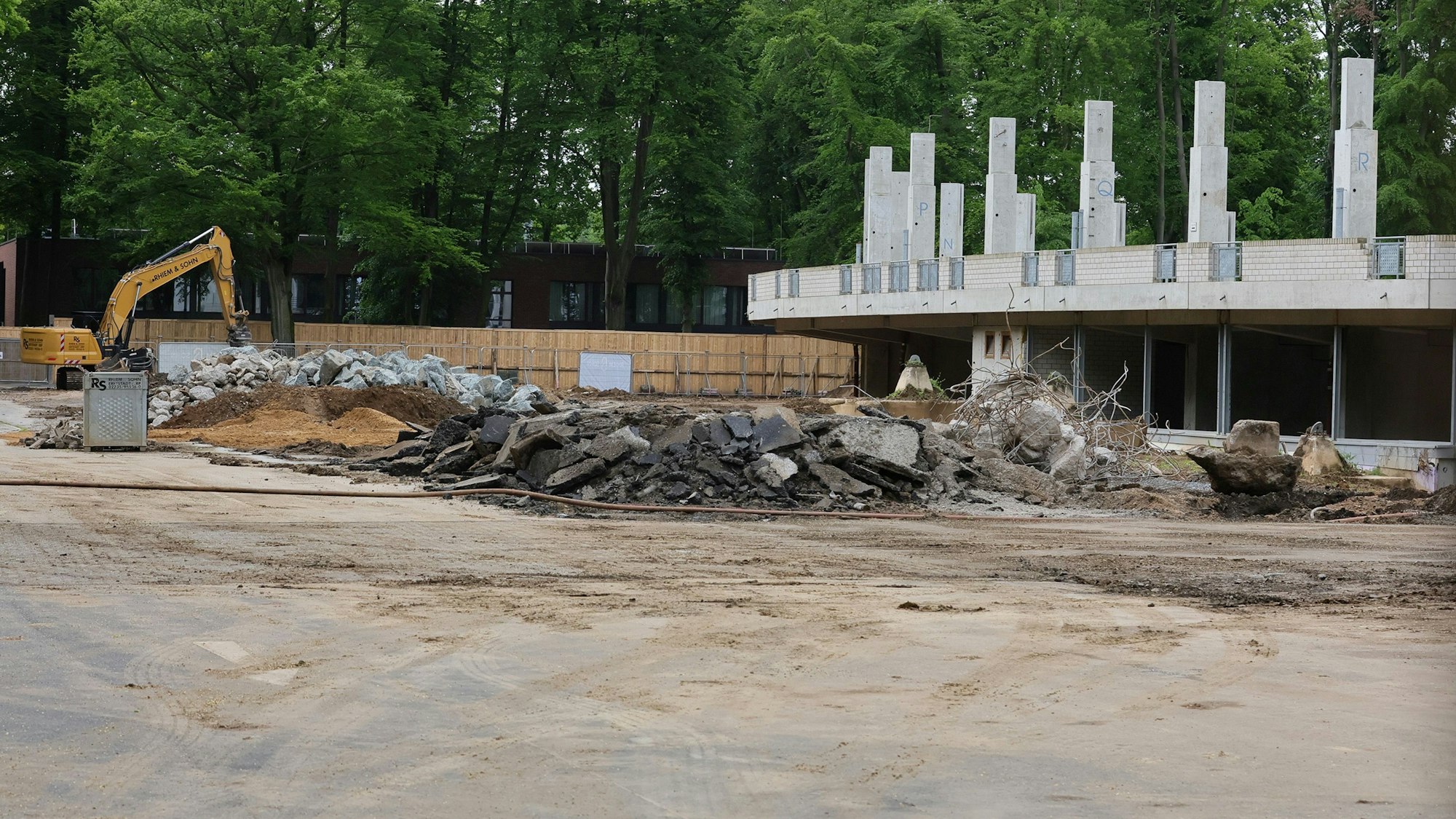 Das Bild zeigt einen Bagger und Reste der Radrennbahn.