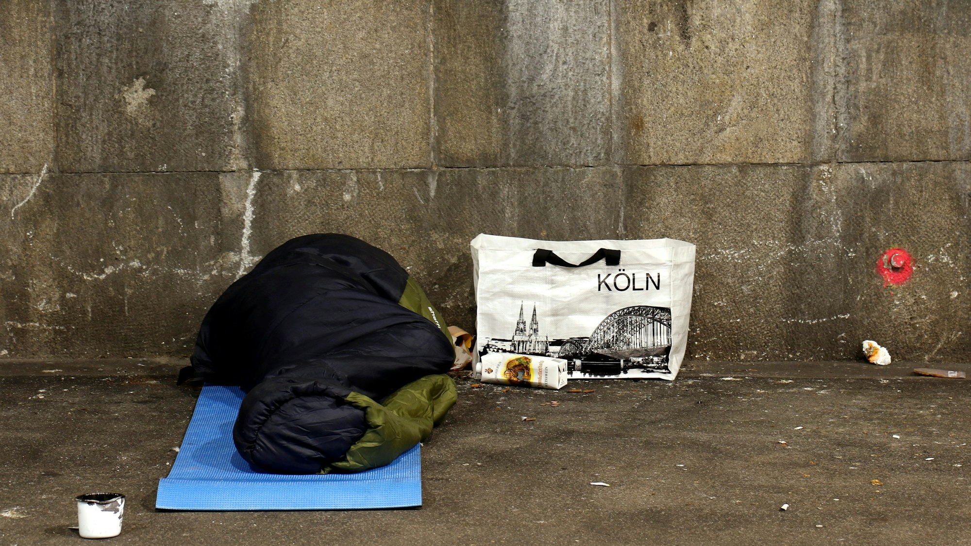 Ein Mann schläft in der Nähe des Hauptbahnhofs in einer Unterführung.