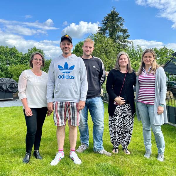 Fünf Eltern stehen in einem Garten