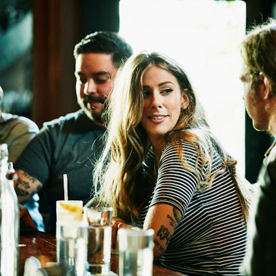 Eine junge Frau flirtet an einer Bar