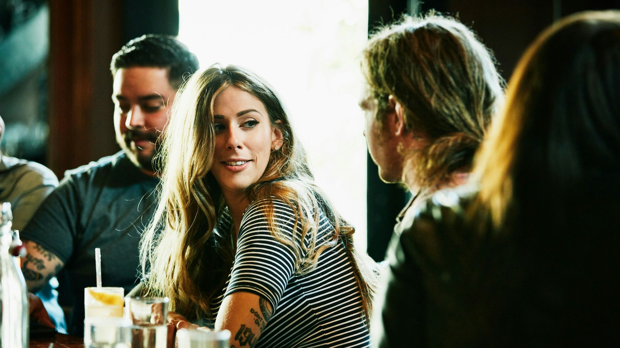 Eine junge Frau flirtet an einer Bar