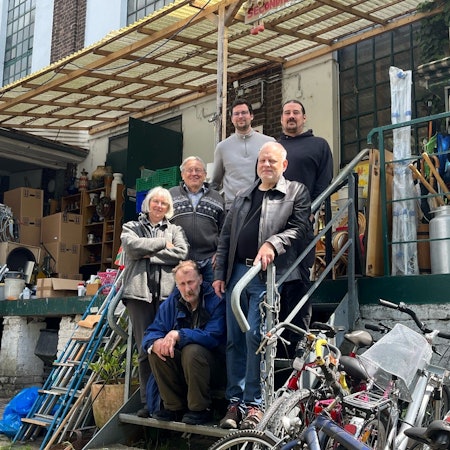 Das Bild zeigt Menschen vor einem Haus.