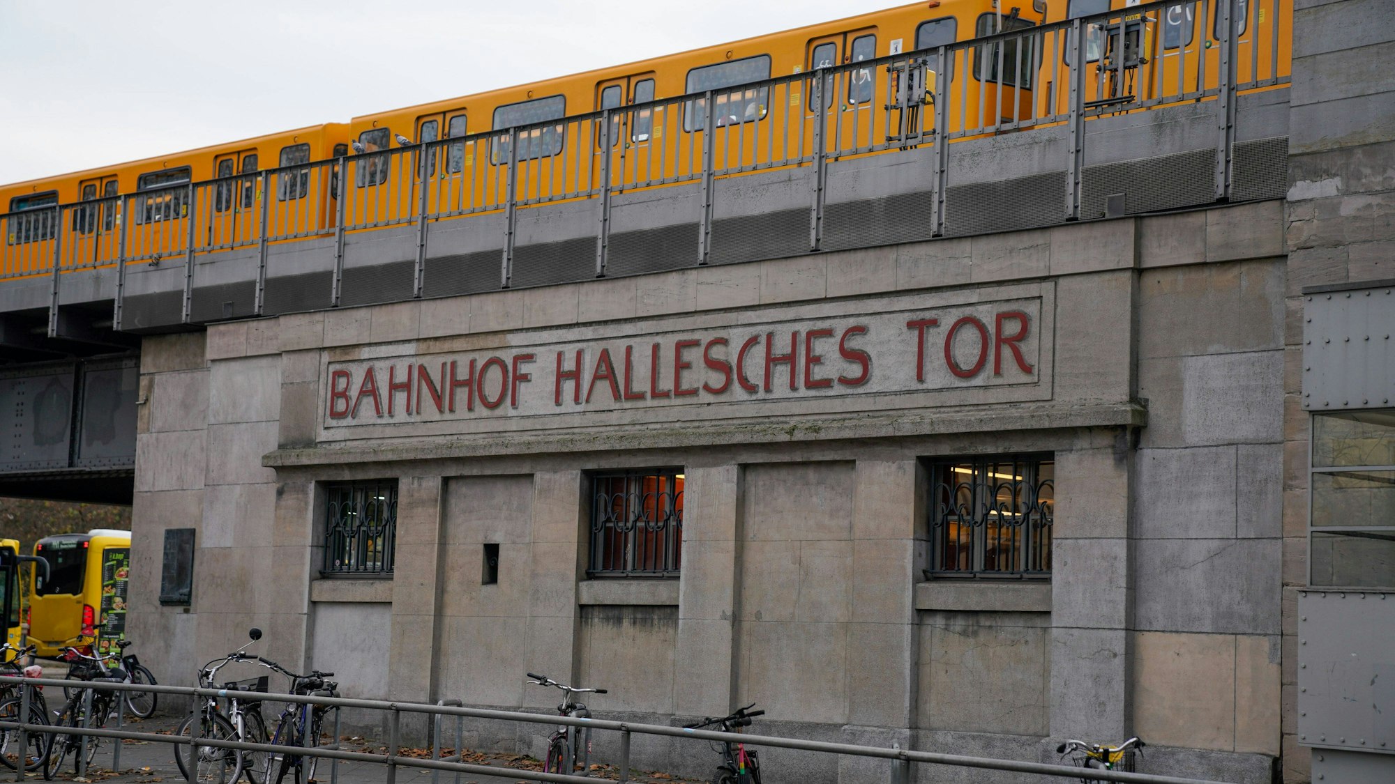 Schriftzug Hallesches Tor, Haltestelle der BVG, ein Zug der U-BAhn fährt darüber Berlin.