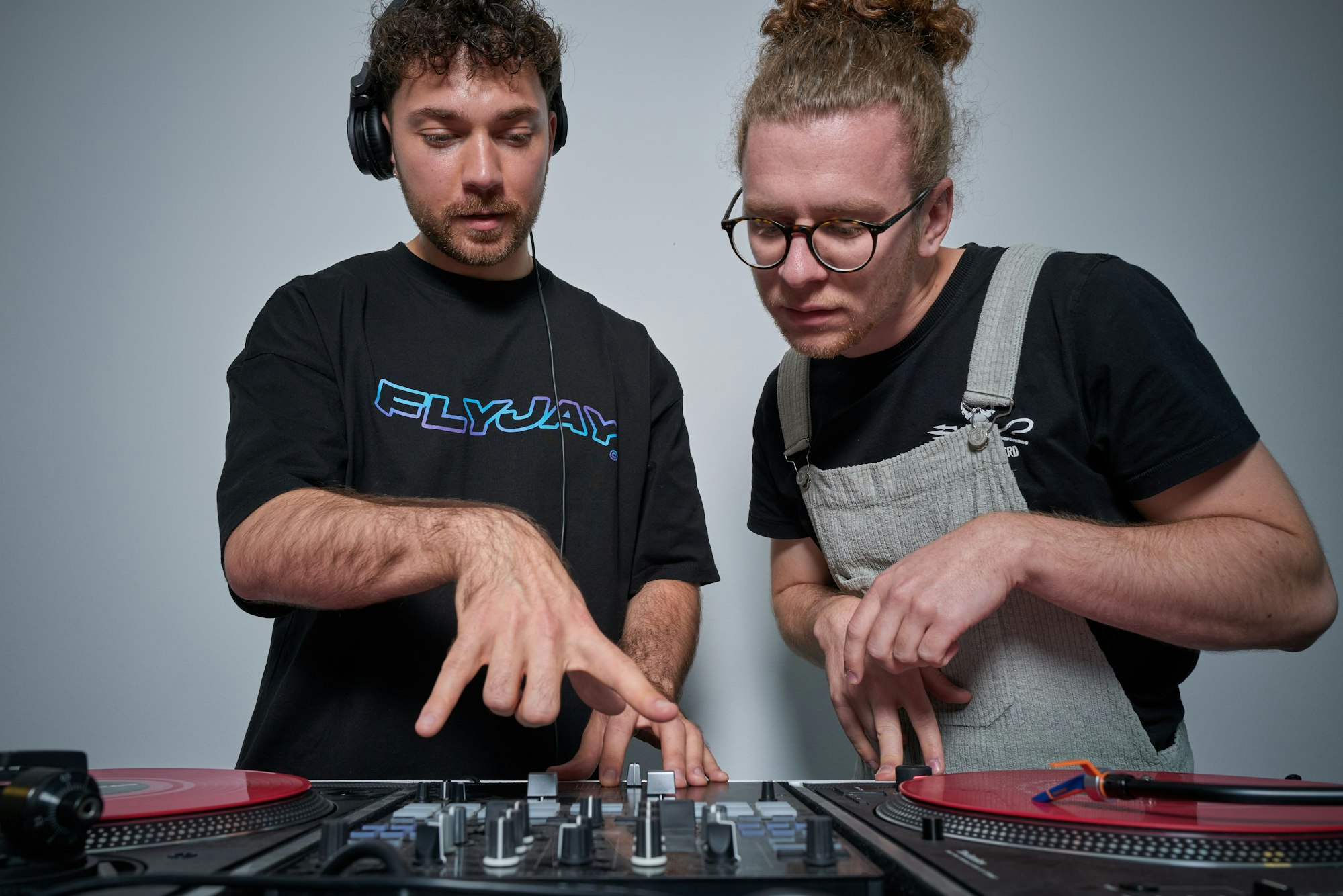 DJ Jason Carter und Student Nils Wiedemeyer schauen auf das DJ-Mischpult