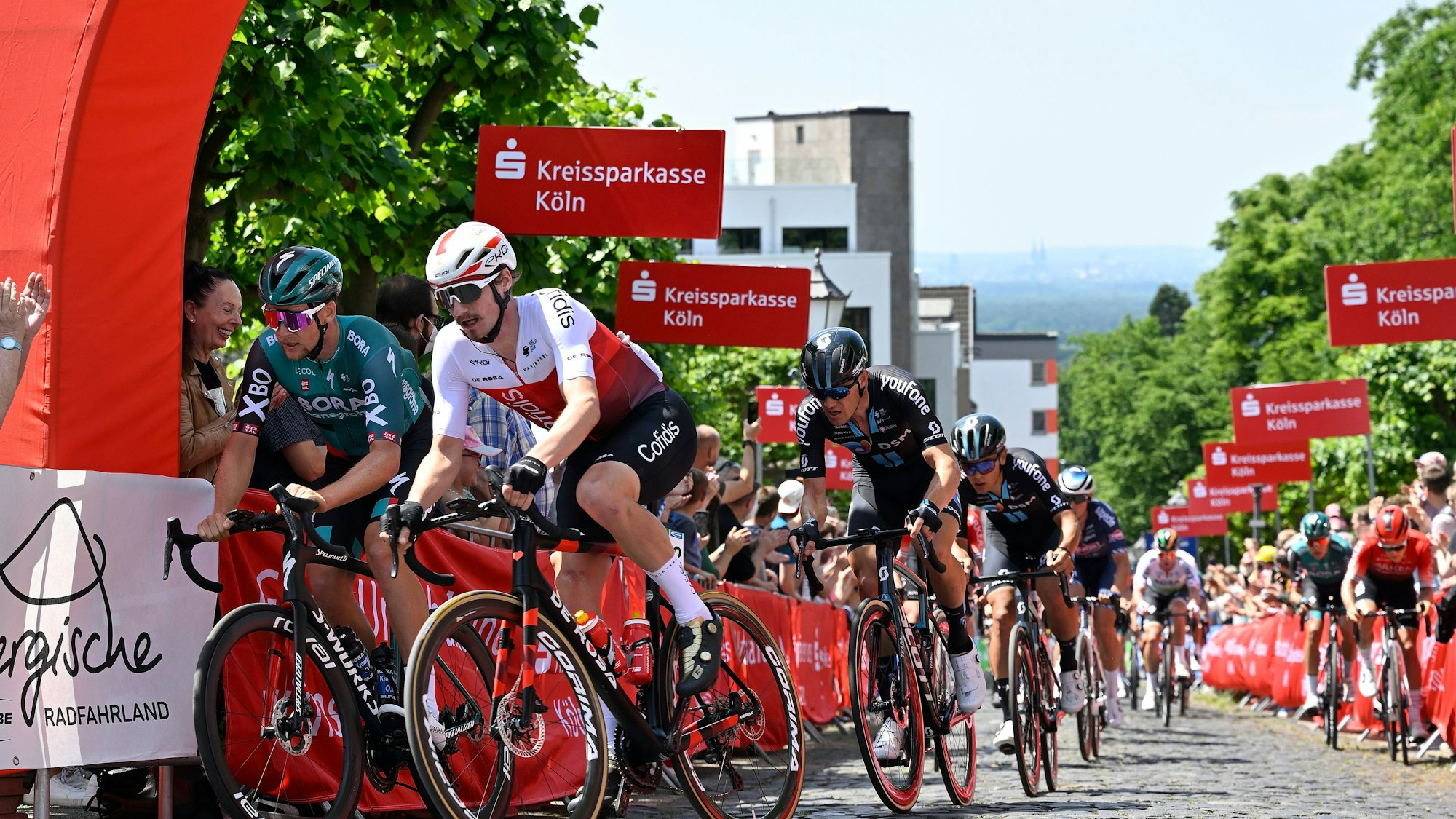 Das Foto zeigt das Elitefeld bei der Bergwertung in Bensberg.