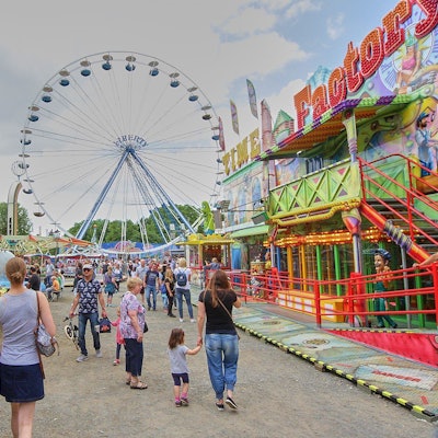 Blick auf ein Riesenrad und Kirmesbuden