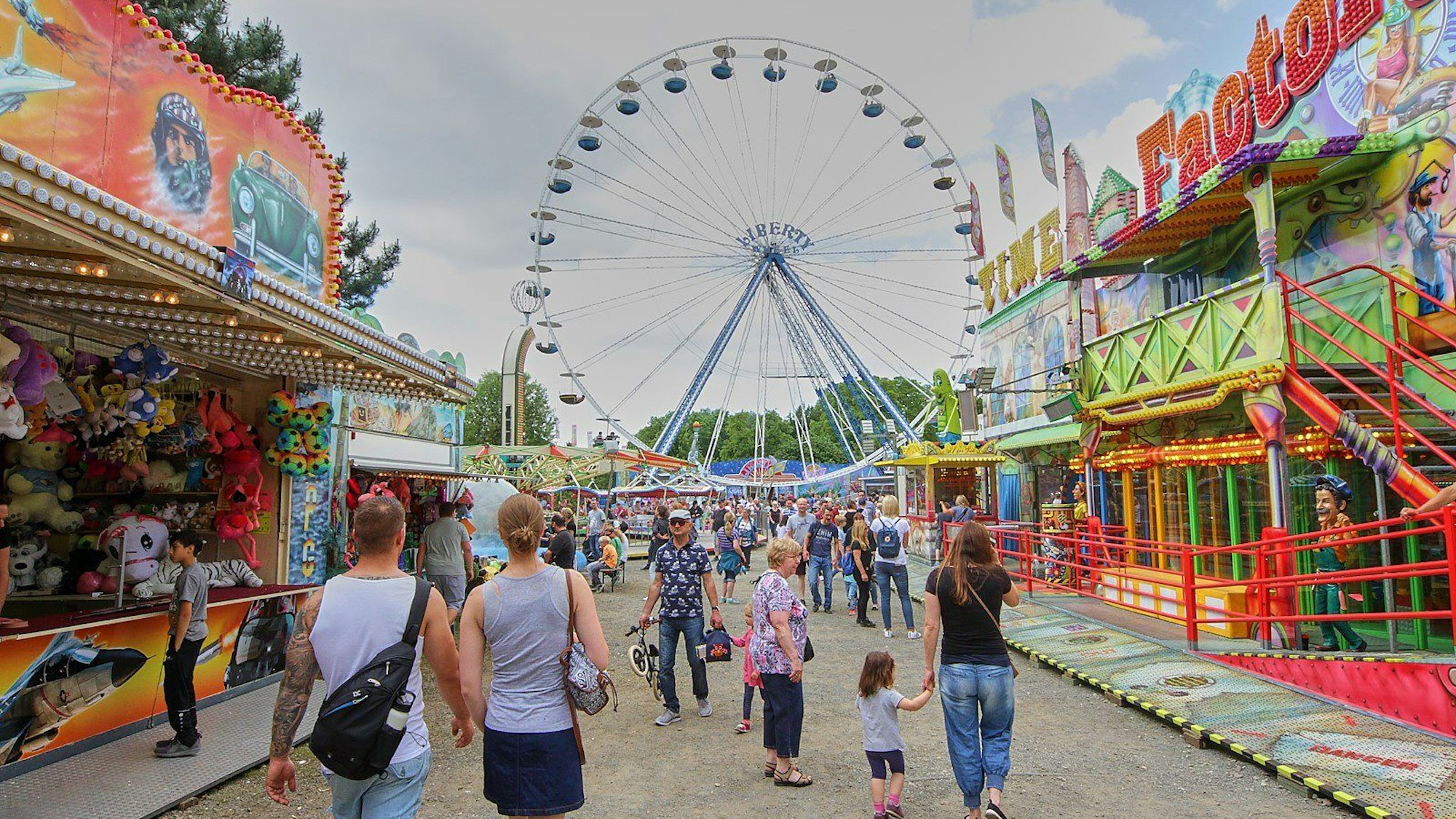 Blick auf ein Riesenrad und Kirmesbuden