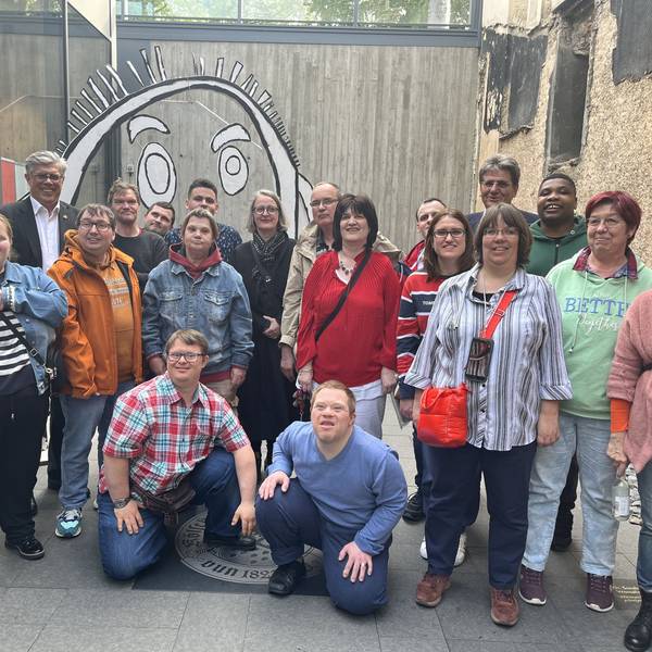 Eine Gruppe von Menschen steht in einer Einfahrt.
