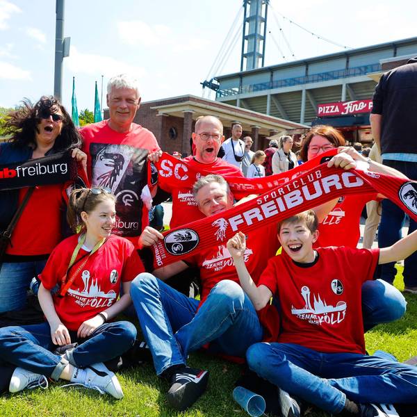 Fans vom SC Freiburg feiern vor dem DFB-Pokalfinale der Frauen und halten Schals in die Luft.
