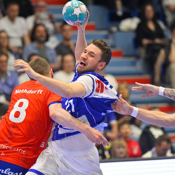 Ein Handballer wird im Angriff von zwei Gegenspielern festgehalten.