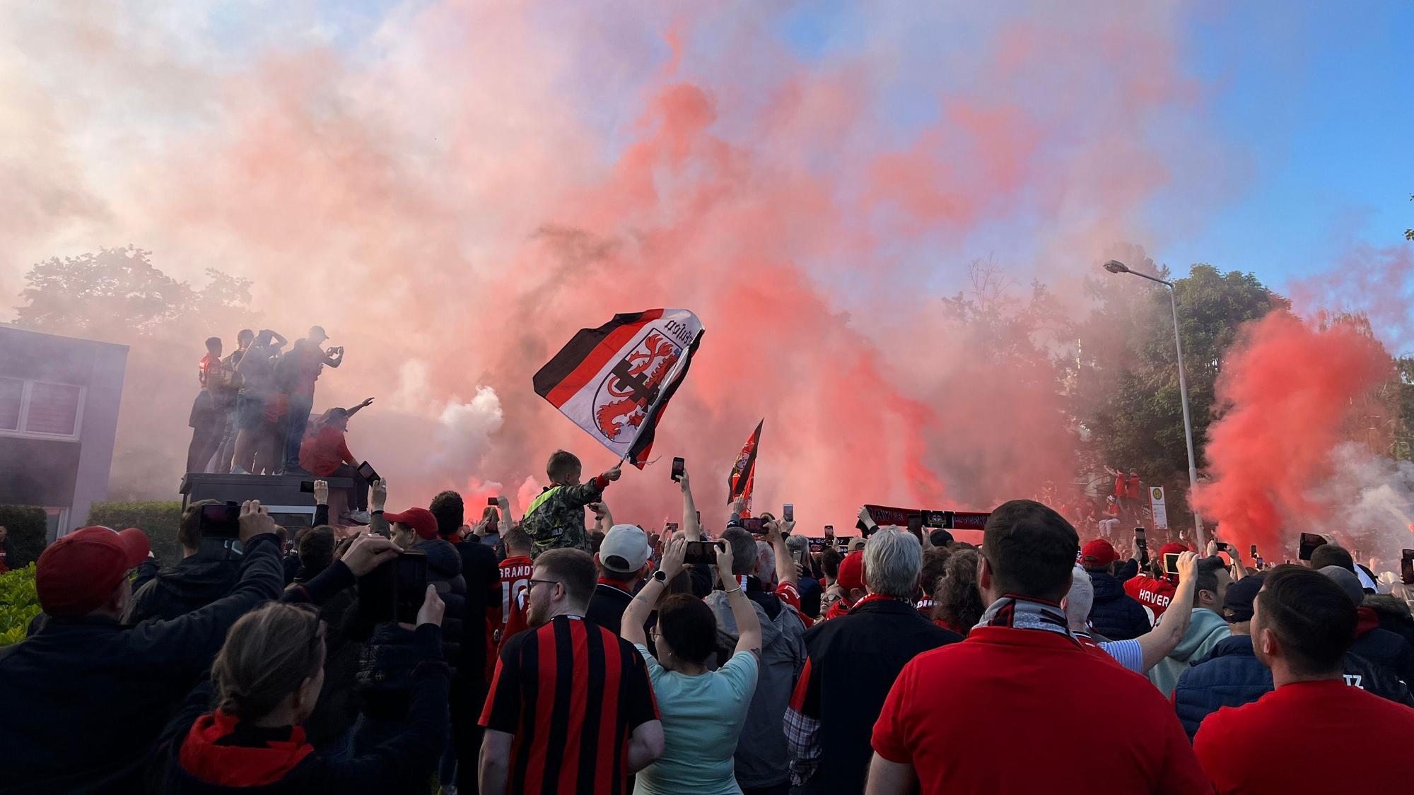 Vor dem Europa-League-Halbfinale in 2023 zünden Bayer-04-Fans Pyro, während sie auf den Mannschaftsbus warten.