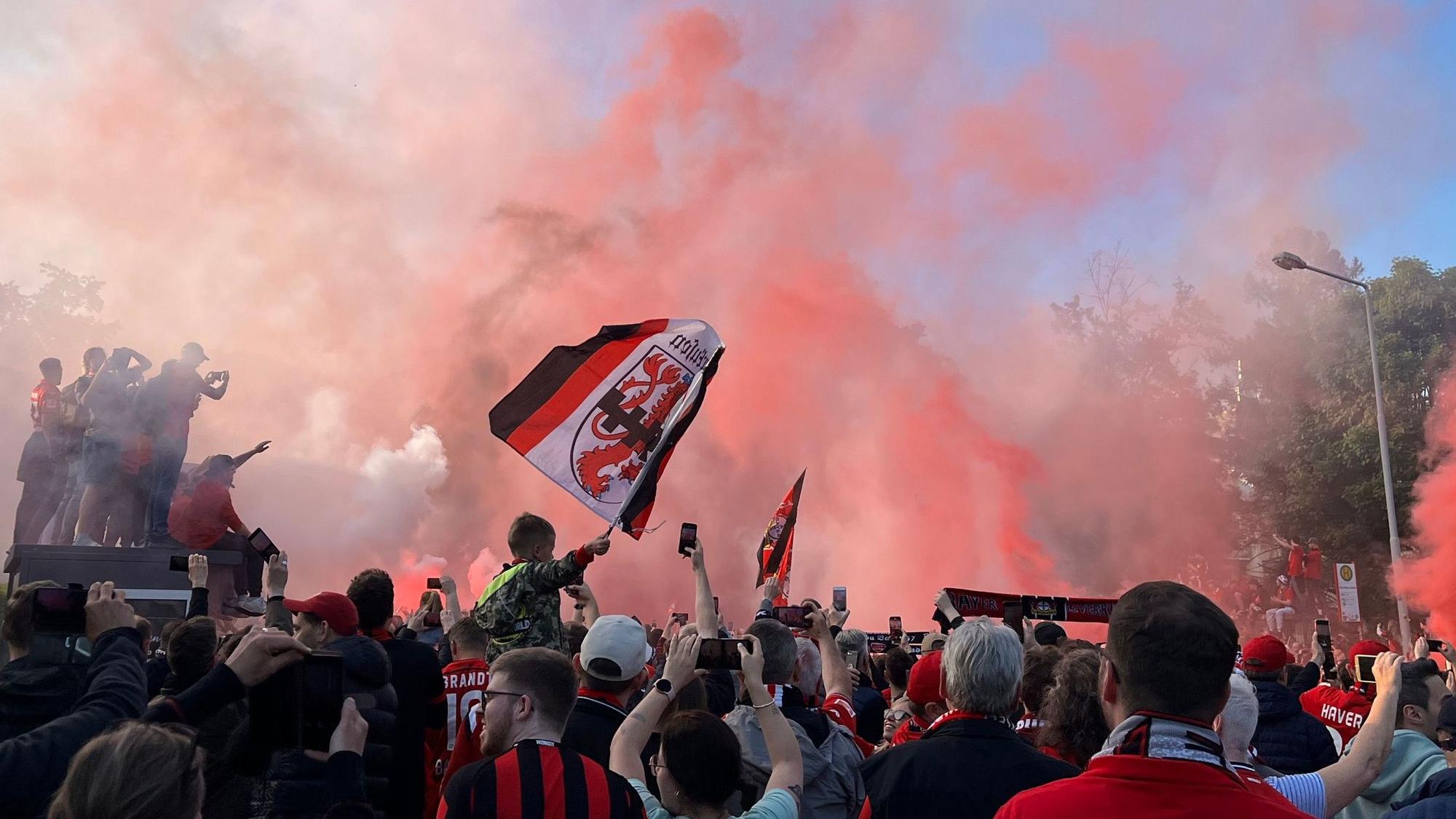 Bayer-04-Fans zünden Pyro, während sie auf den Mannschaftsbus warten.