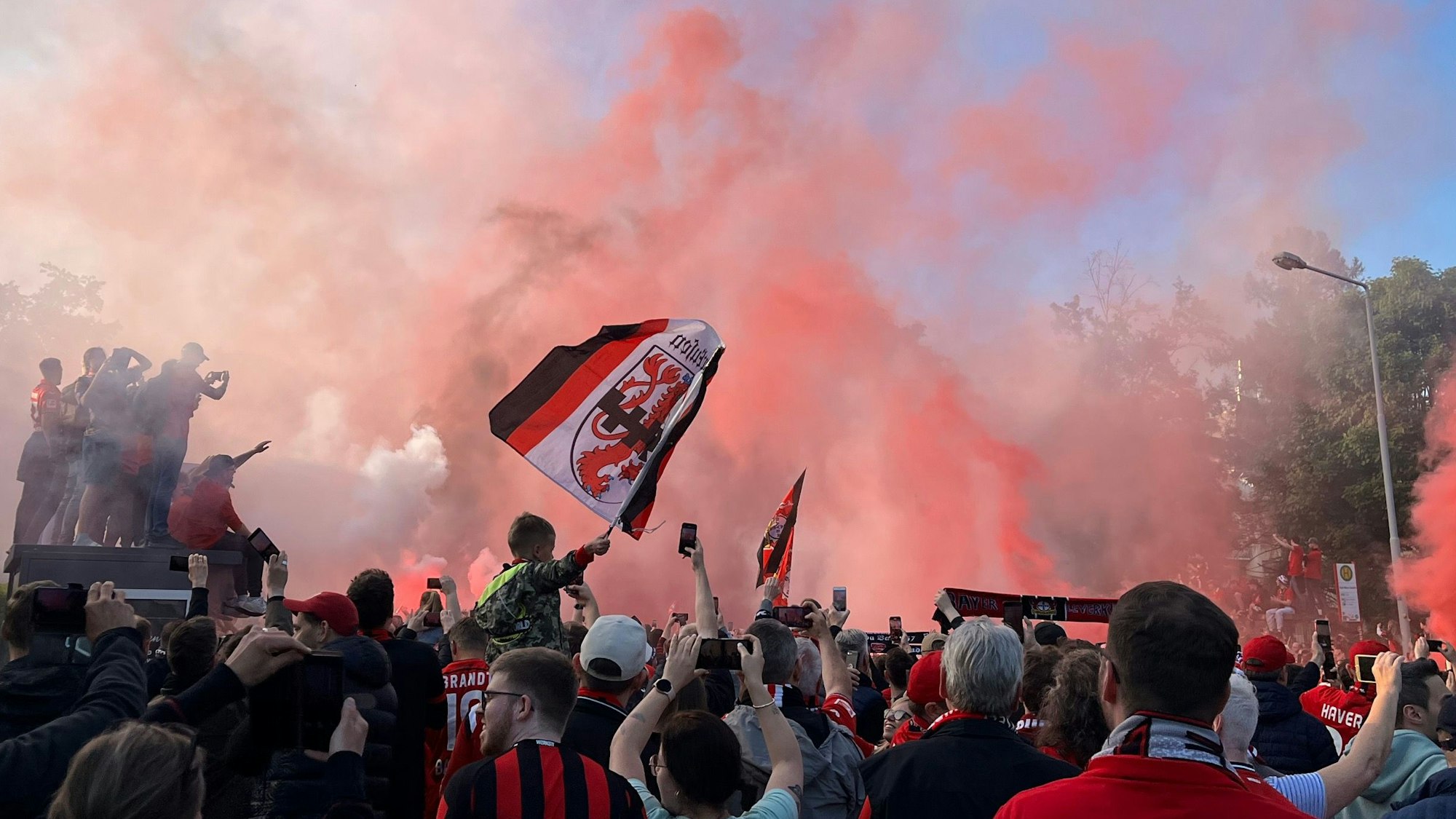 Bayer-04-Fans zünden Pyro, während sie auf den Mannschaftsbus warten.