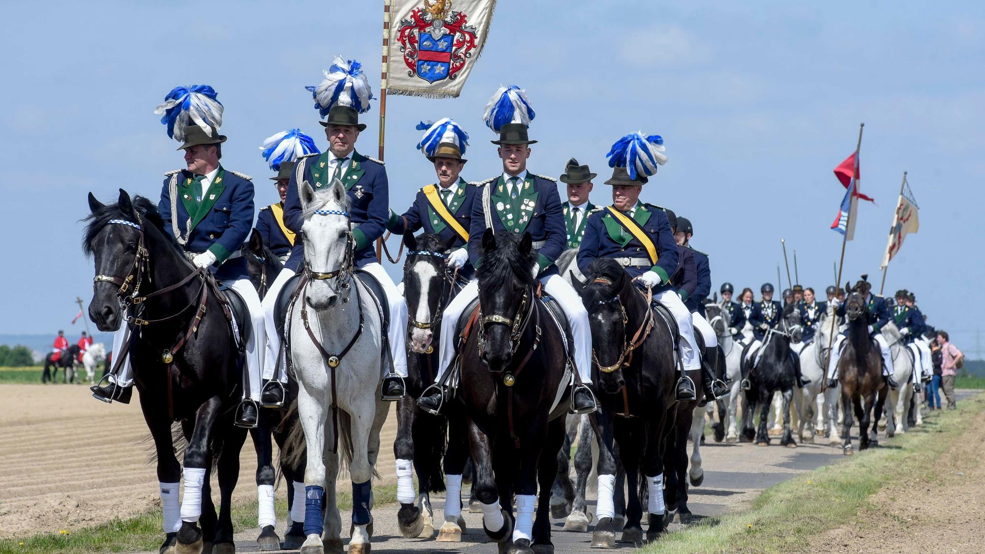 Zu sehen sind Reiter mit einer Flagge.