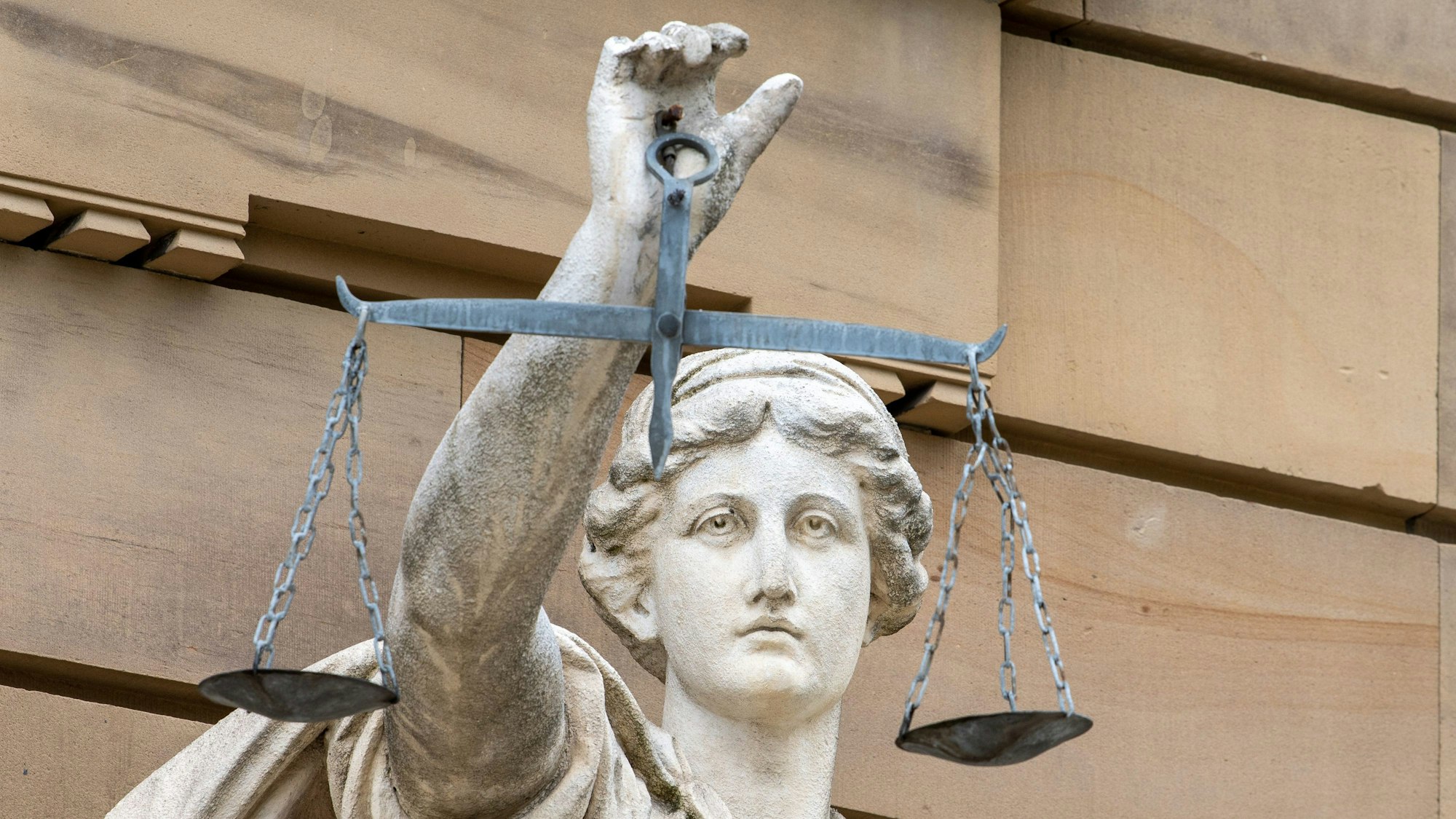 Eine Statue hält eine Waage in der Hand.