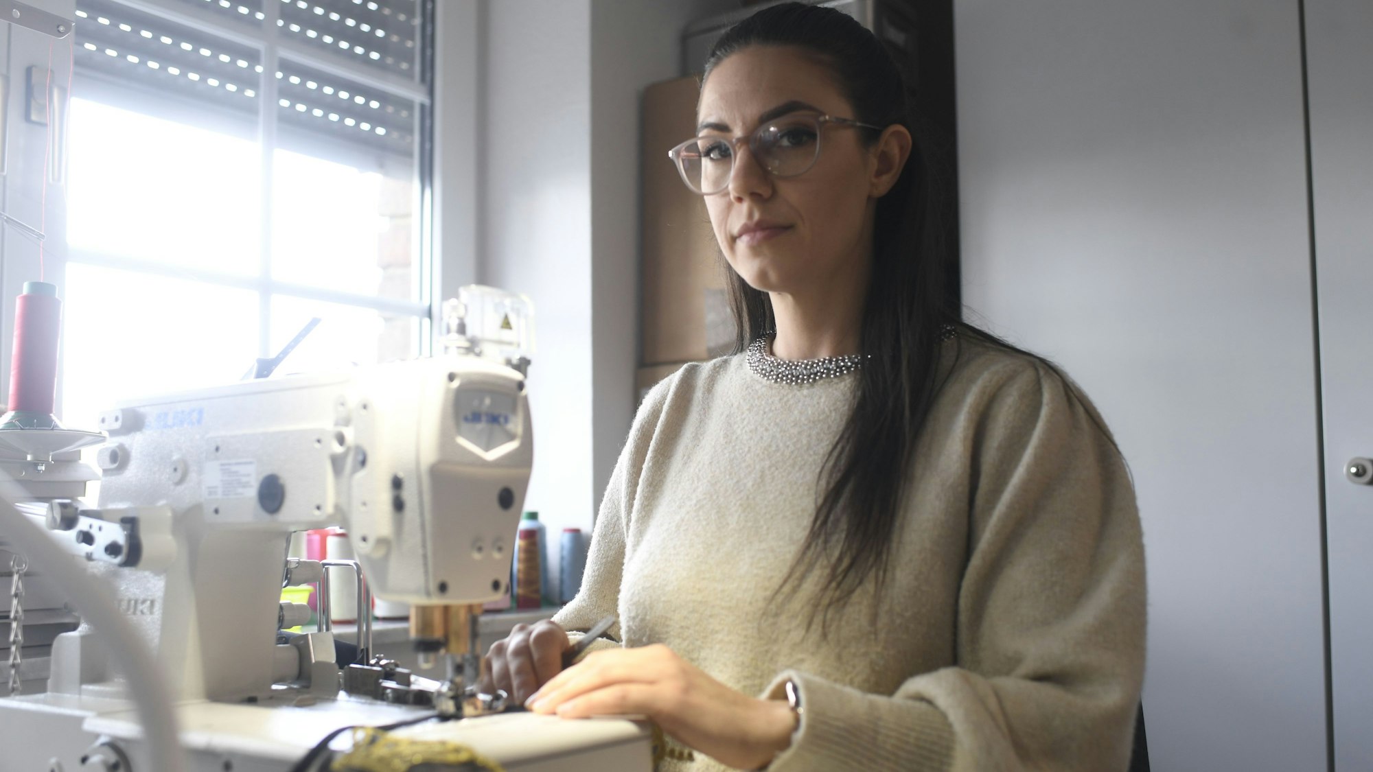 Näherin Carina Käfer arbeitet an einer Nähmaschine.