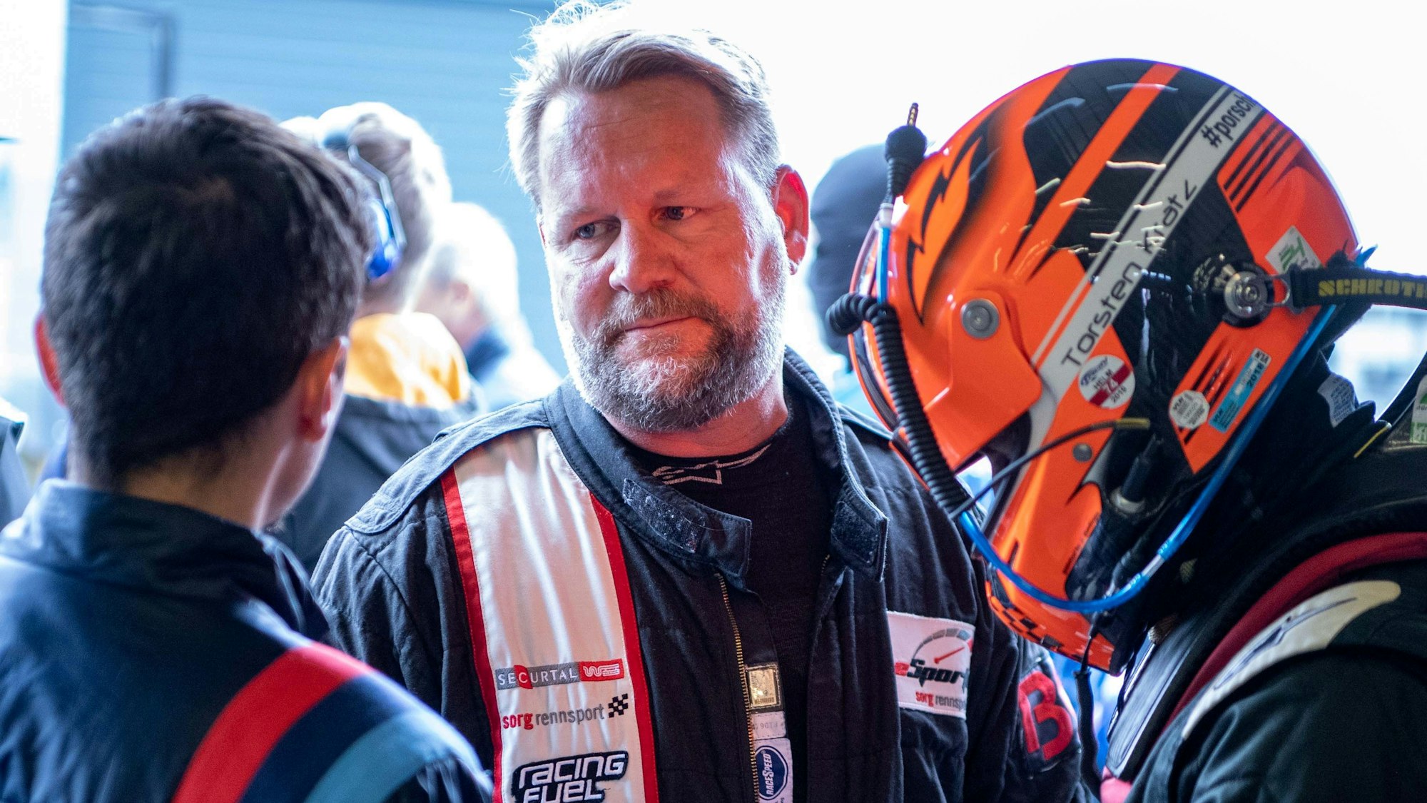 Der Weilerswister Rennfahrer Björn Simon vor dem Start beim 24h. Er ist im Gespräch mit einem Mechaniker.