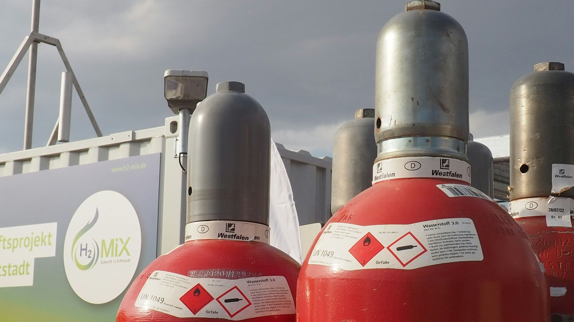 Rote Flaschen mit einem Metall-Aufsatz, gefüllt mit Wasserstoff.