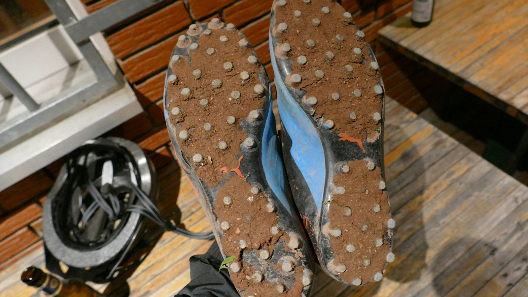 Zwischen den Stollen in den Sohlen von Fußballschuhen klebt die Erde vom Ascheplatz.