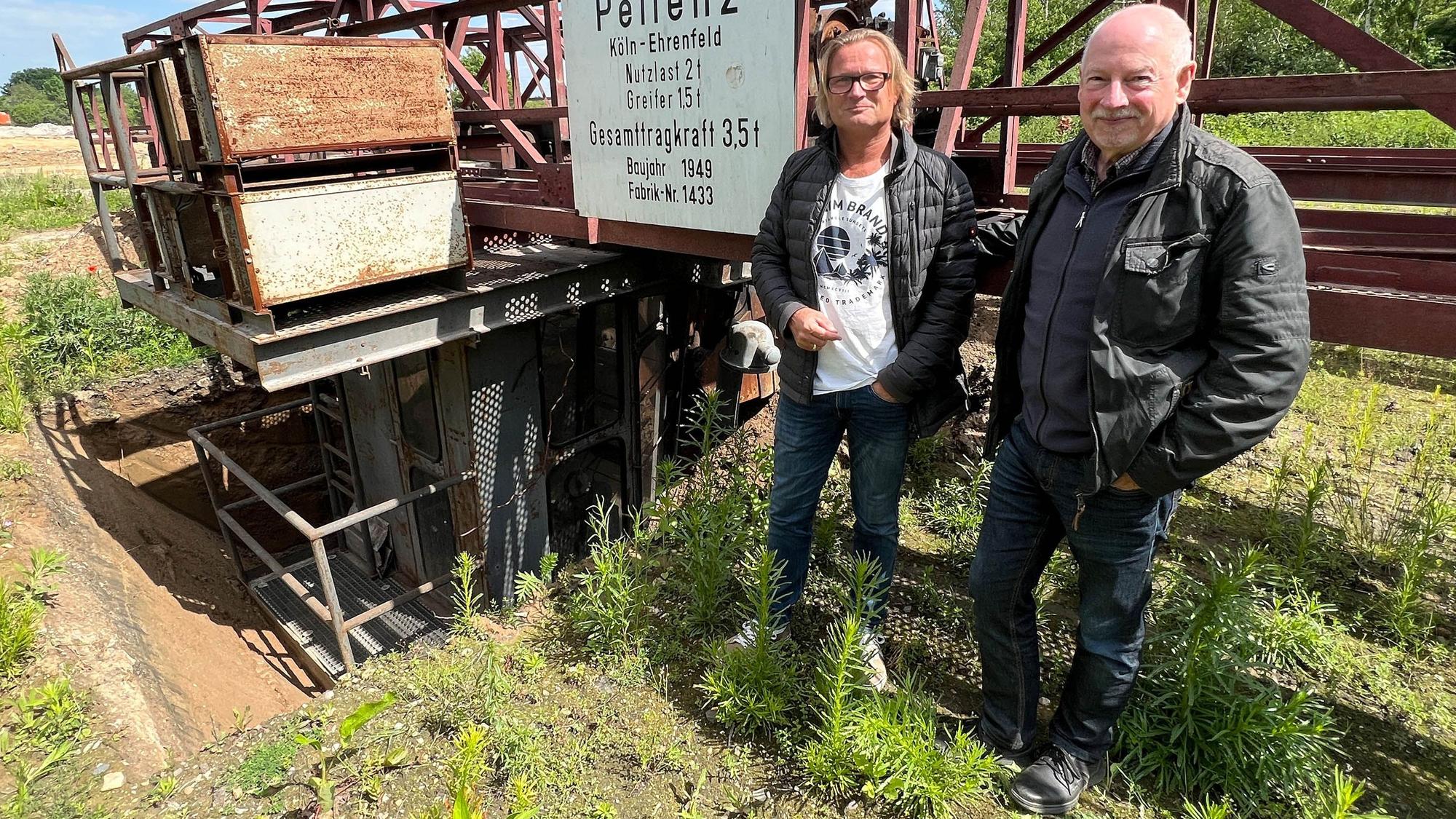 Das Foto zeigt Branko Appelmann und Bert Wallraf vom Heimatverein Sindorf vor dem Brückenkran.