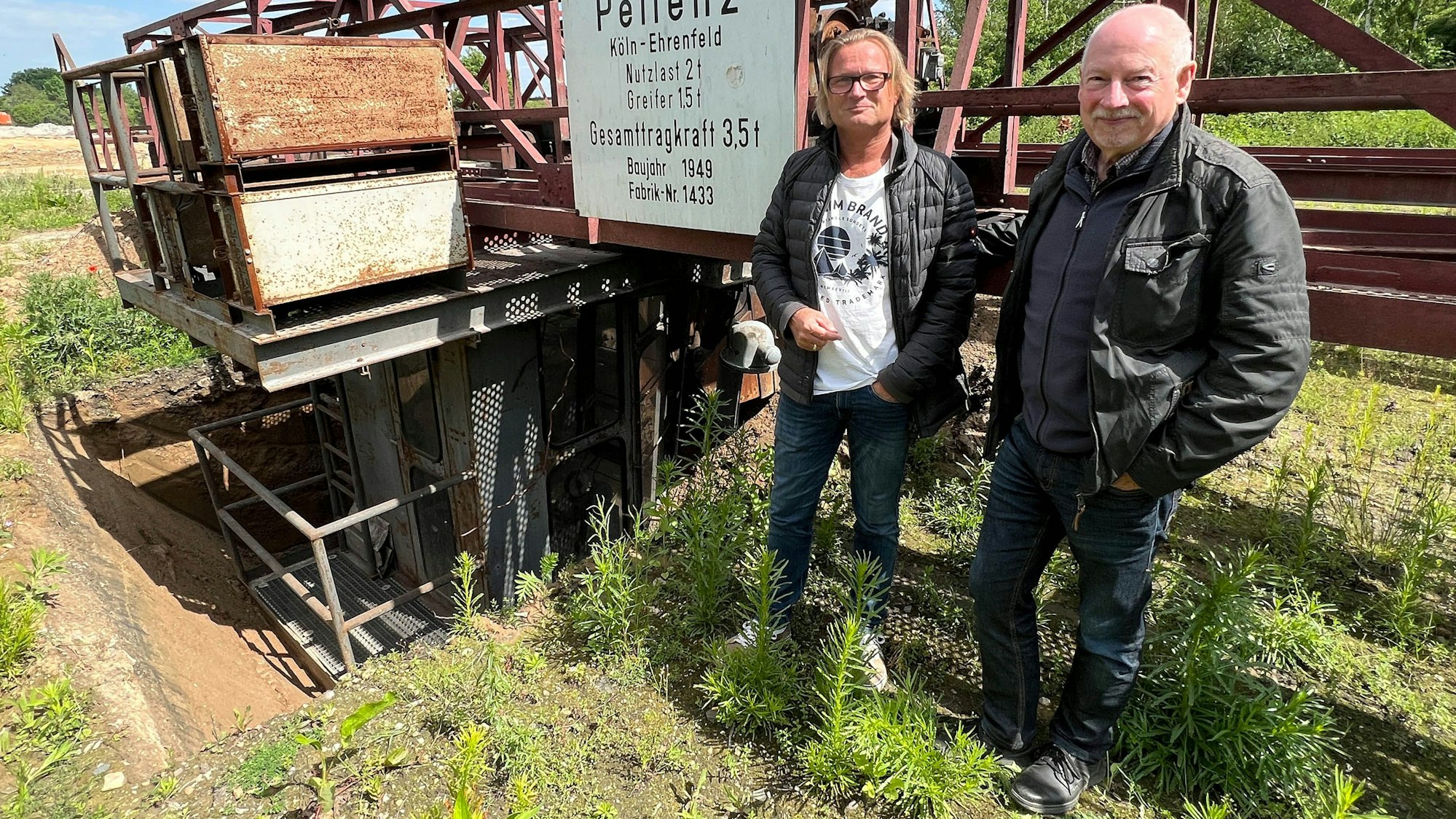 Das Foto zeigt Branko Appelmann und Bert Wallraf vom Heimatverein Sindorf vor dem Brückenkran.