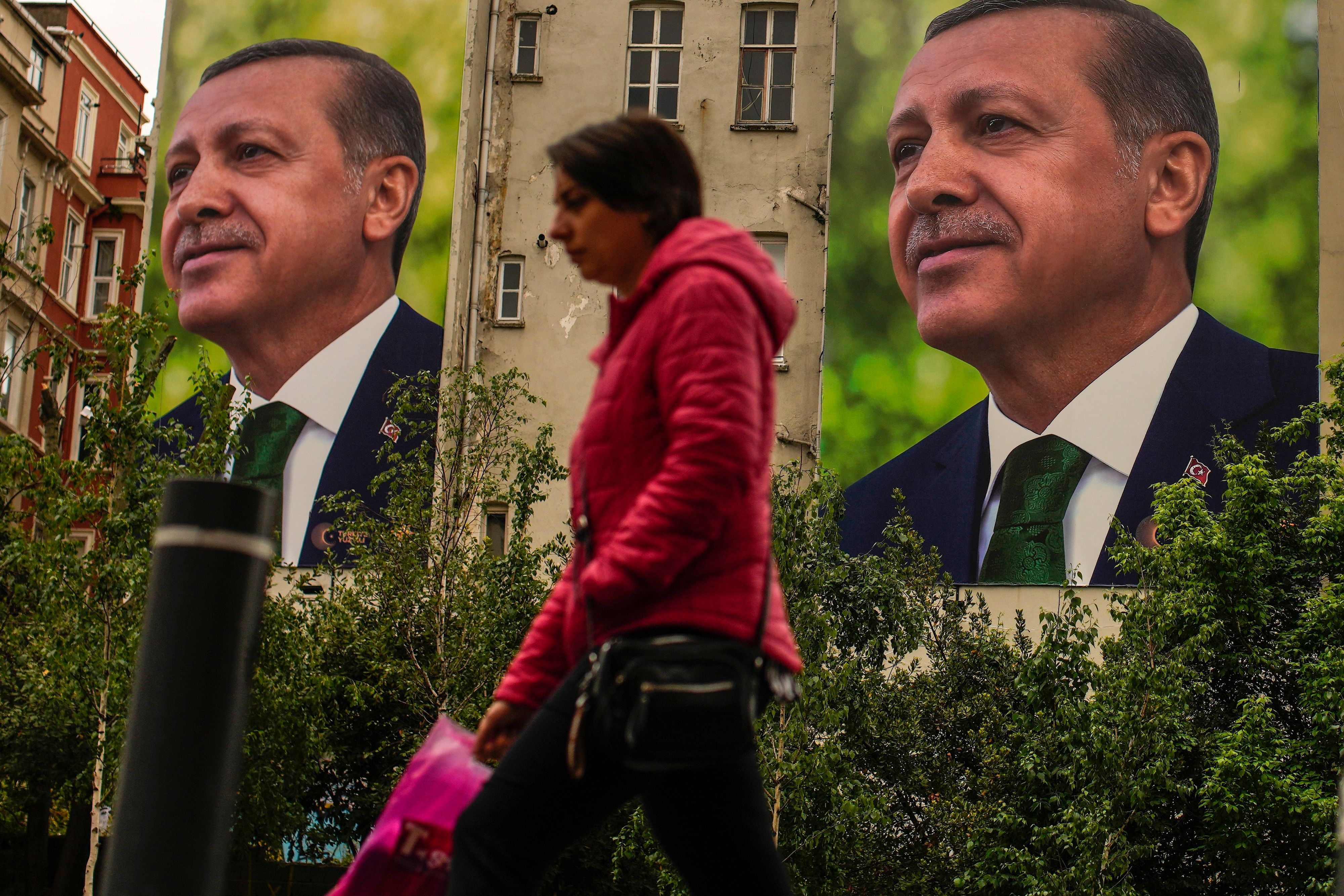 Eine Frau geht an Plakaten des türkischen Präsidenten und des Präsidentschaftskandidaten der Volksallianz, Erdogan, vorbei.