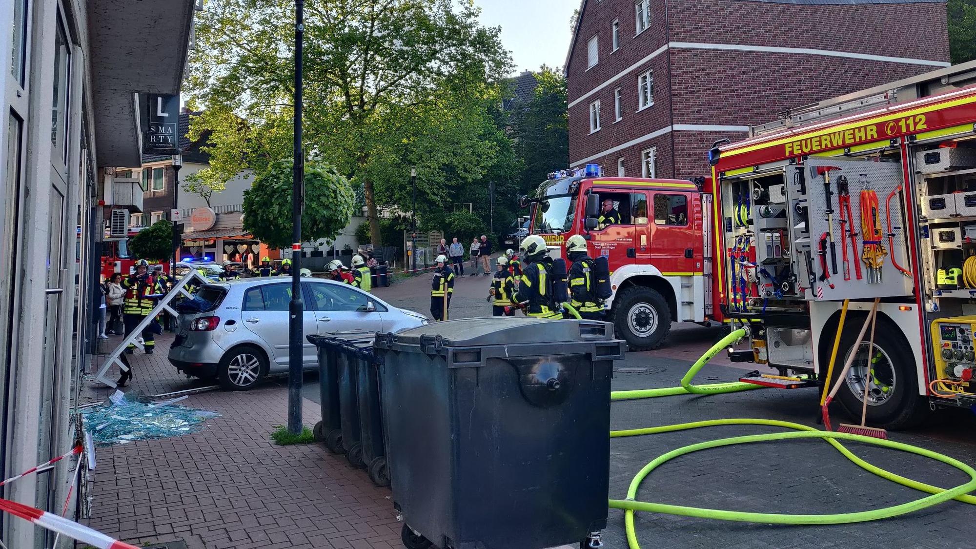 An der Seilwinde zieht die Feuerwehr den VW aus dem Ladenlokal, ein Regal steckt noch im Heckfenster fest.