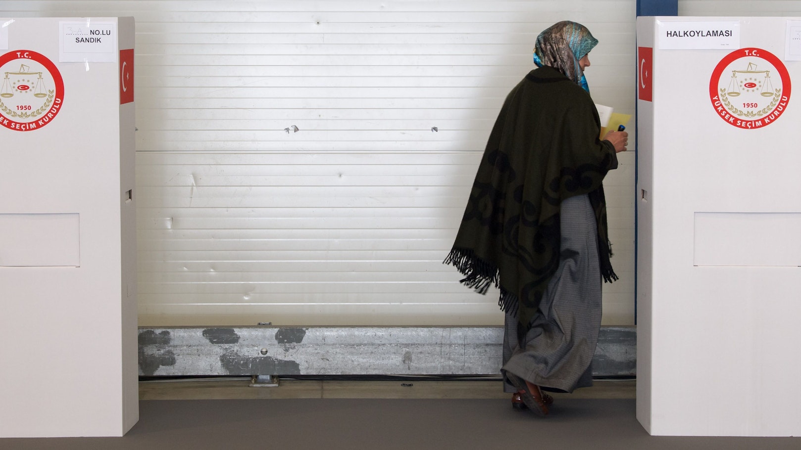 Eine Türkin geht in die Kabine eines Wahllokals.