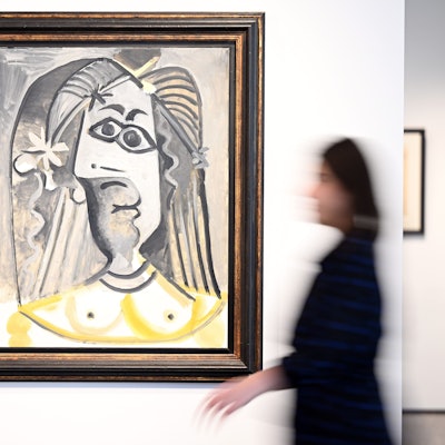 Eine Mitarbeiterin des Auktionshauses Van Ham geht am Bild "Buste de femme" aus dem Jahr 1971 von Pablo Picasso vorbei.