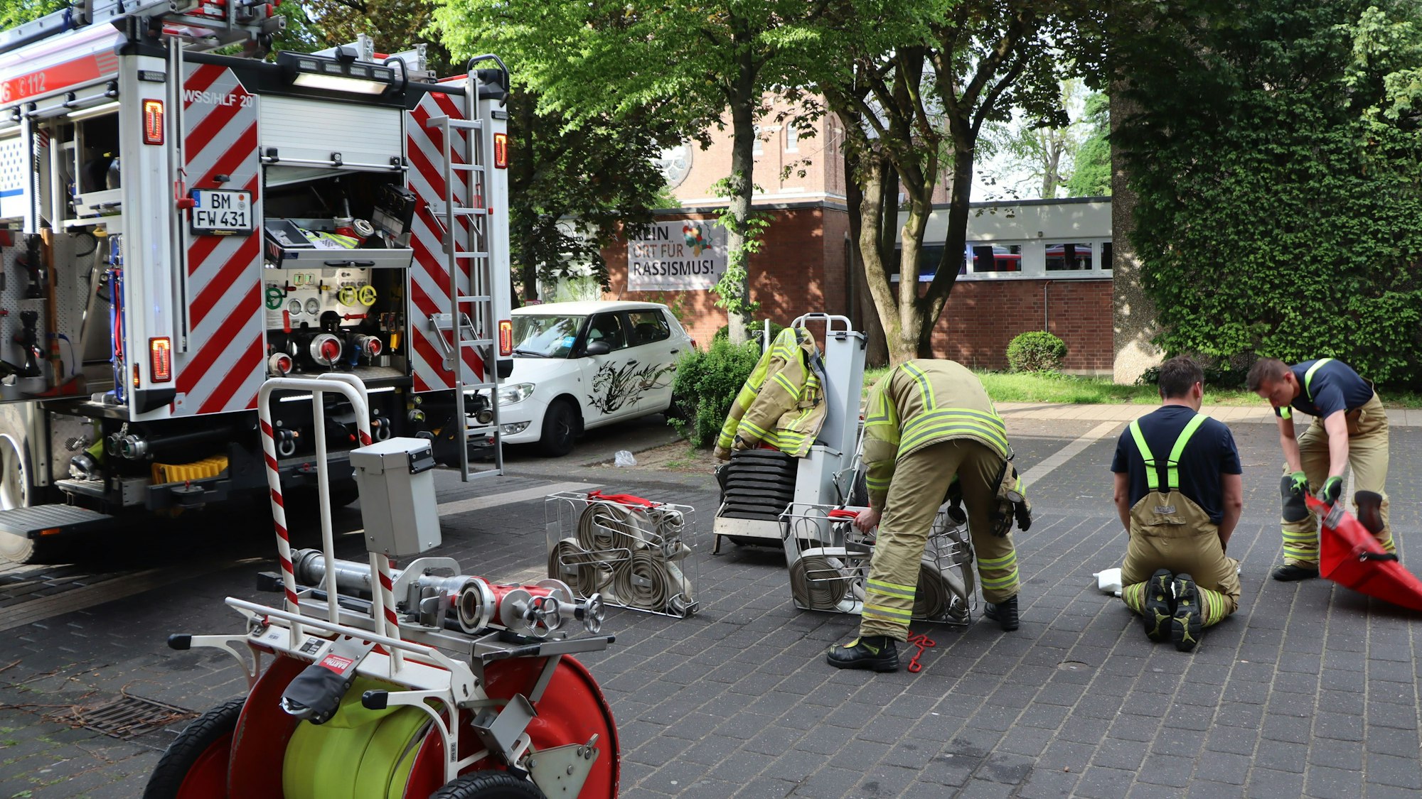 Man sieht Feuerwehrleute, die Ausrüstung verstauen.