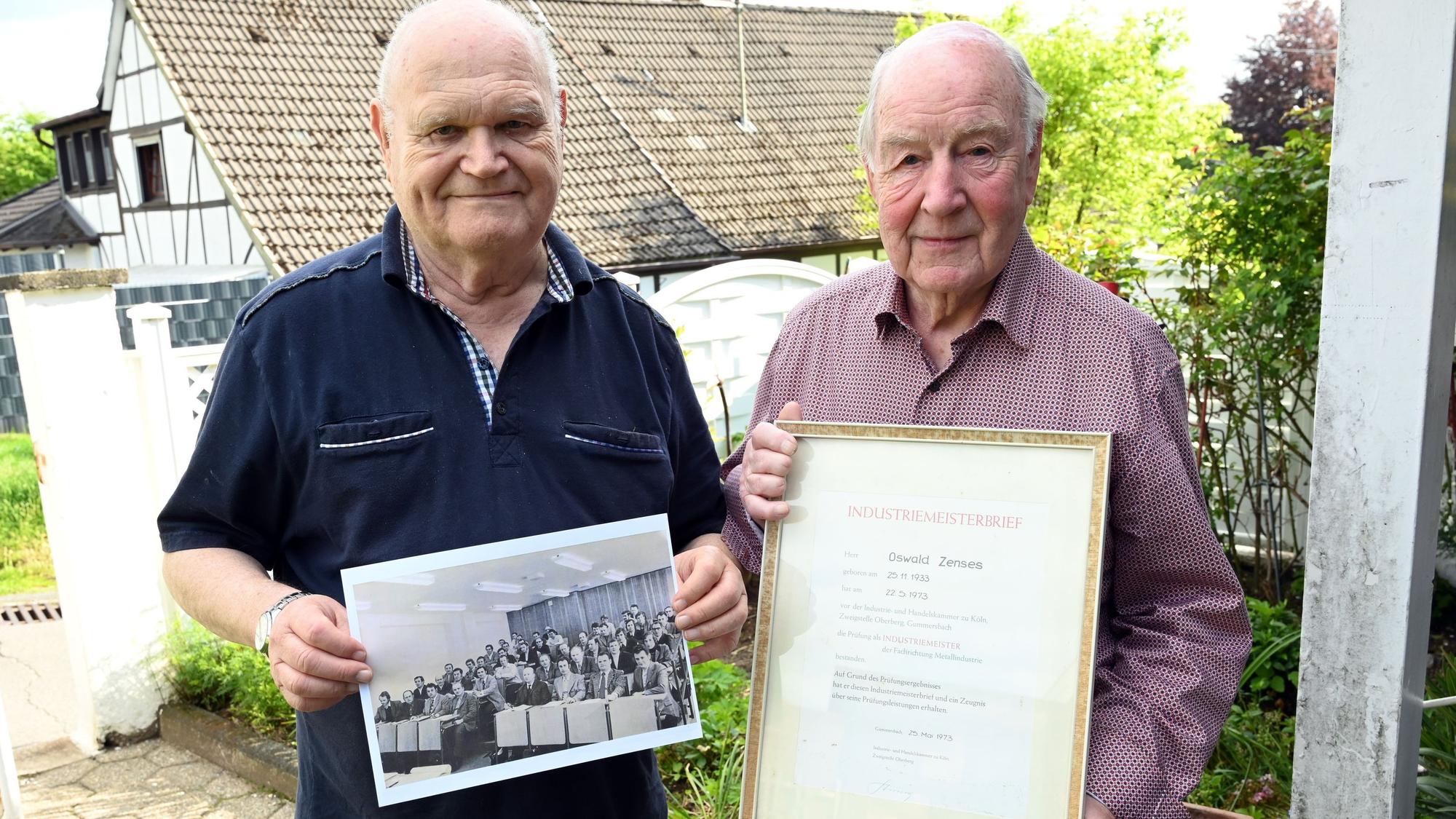 Zu sehen sind zwei Männer mit Meisterbrief und historischem Bild.
