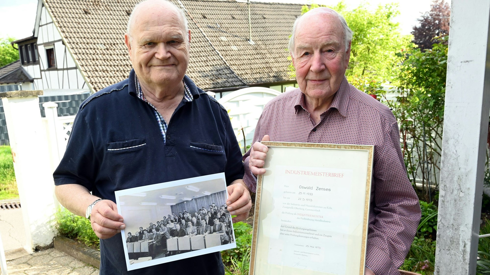 Zu sehen sind zwei Männer mit Meisterbrief und historischem Bild.