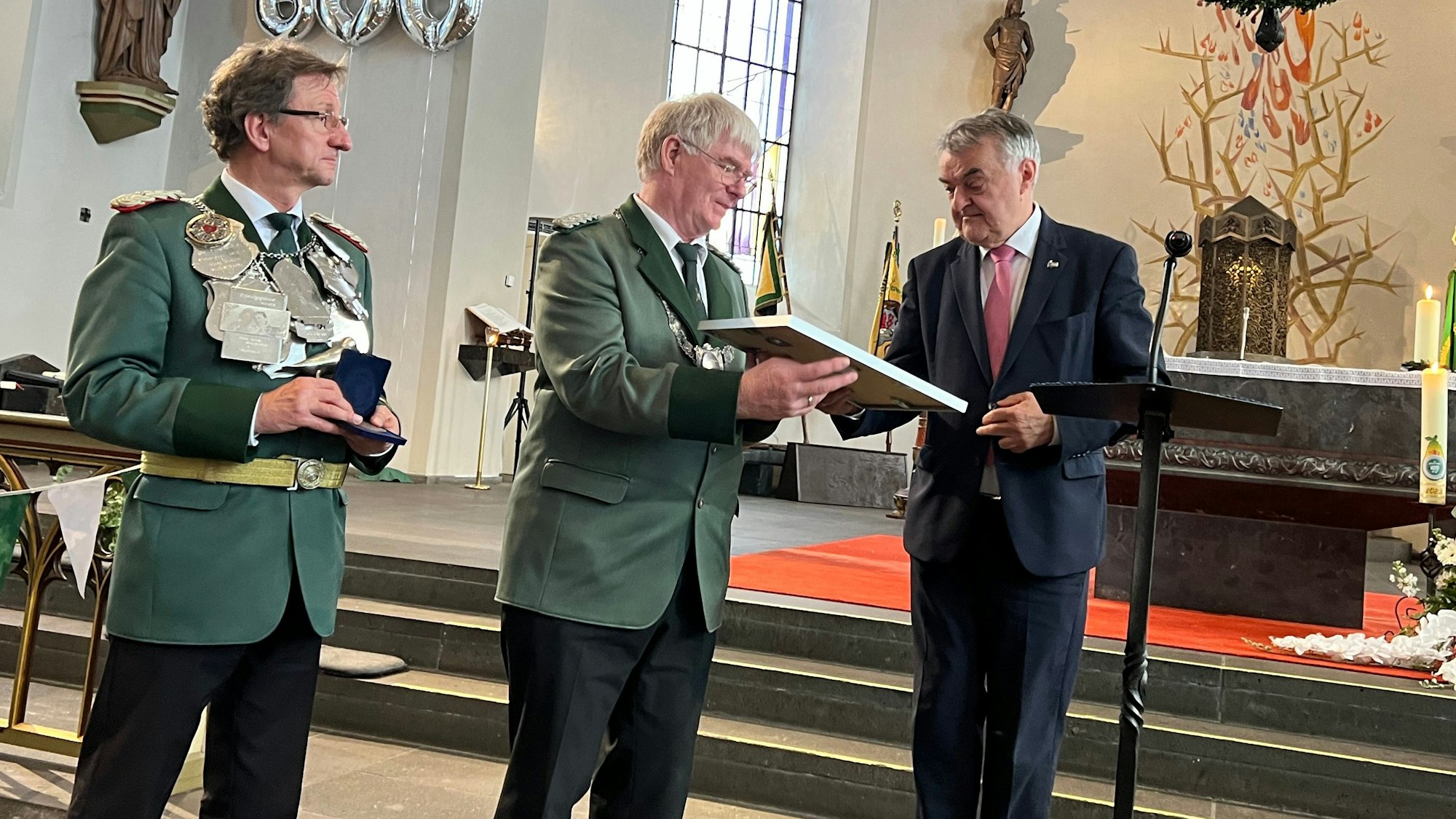 Herbert Reul (r.) überreicht den LÜtzenkirchener Schützen die Ehrenplakette des Landes Nordrhein-Westfalen.