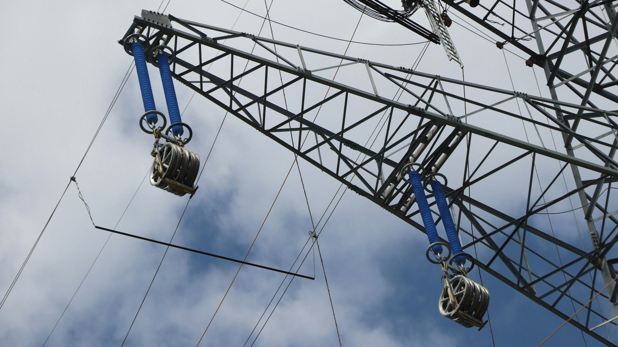 Das Bild zeigt einen Hochspannungsmast, der gerade gebaut wurde und an dem noch keine Stromleitungen hängen.