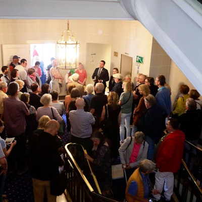 Besucher stehen dicht an dicht im Hotelflur.