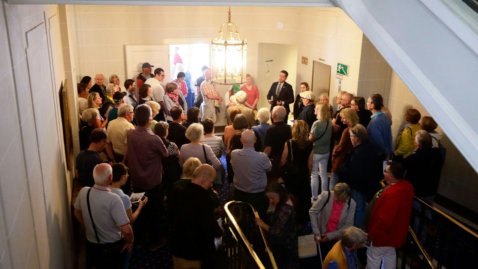 Besucher stehen dicht an dicht im Hotelflur.