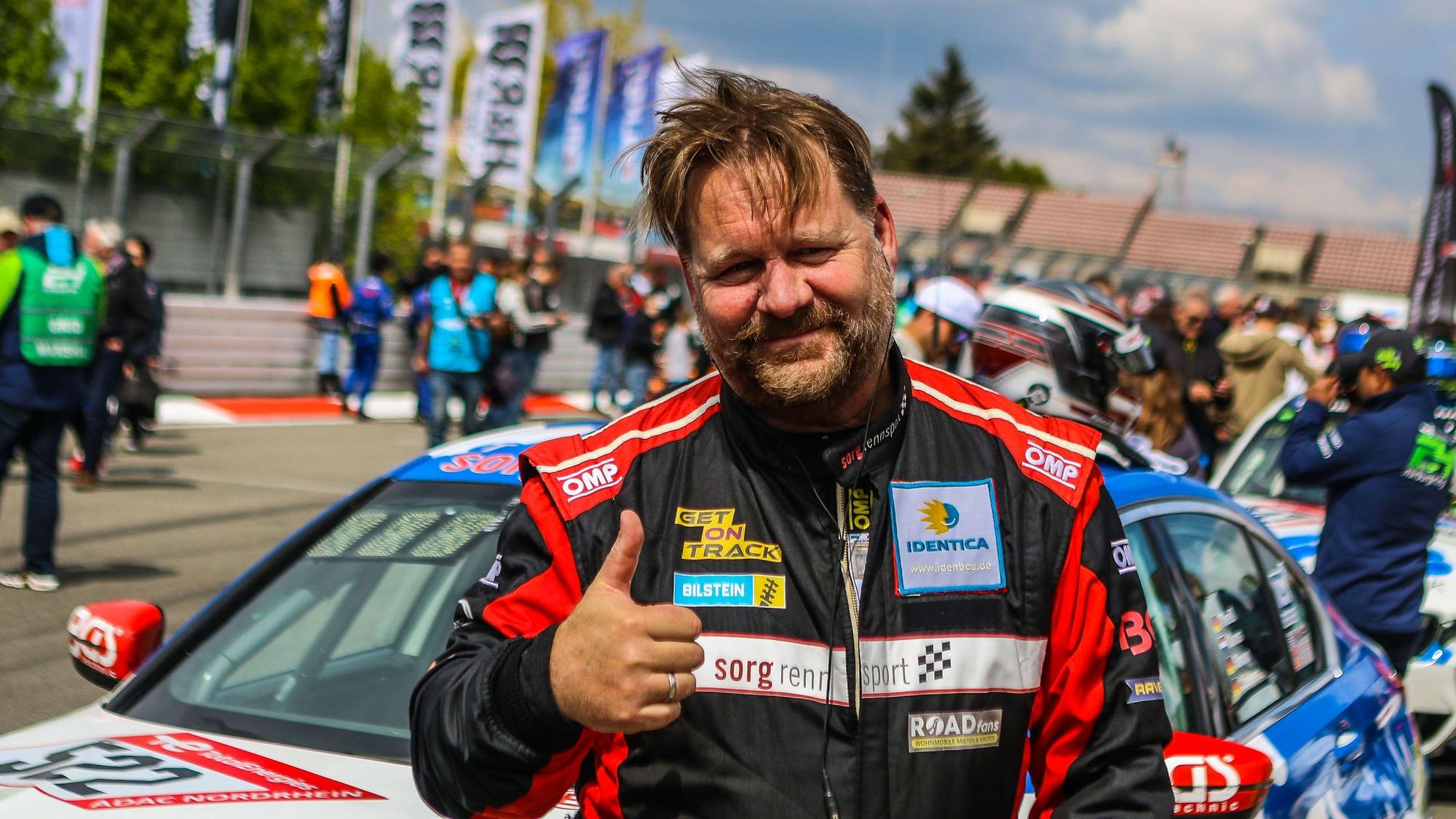 Björn Simon steht vor einem Fahrzeug und reckt den Daumen in die Höhe.