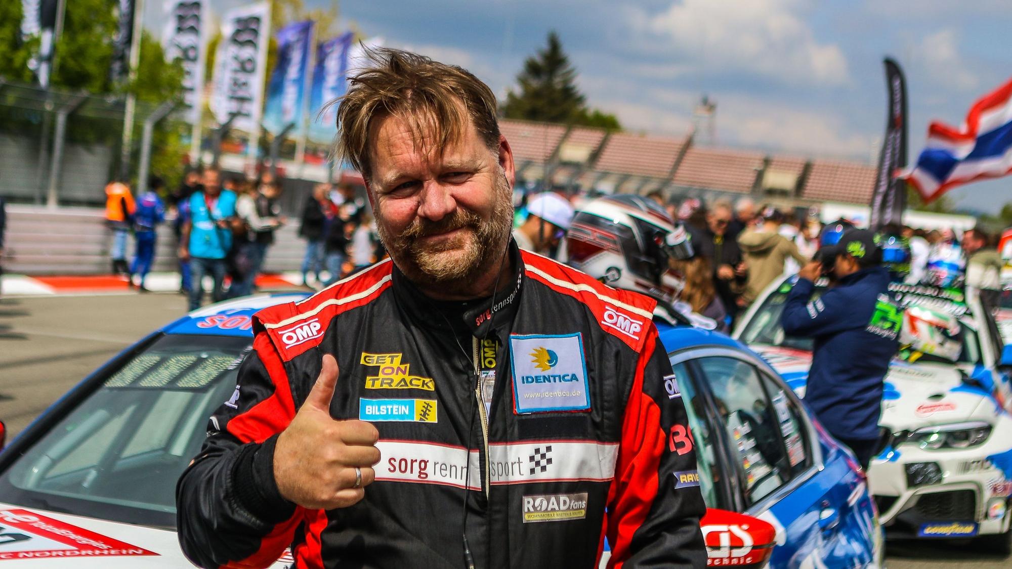 Das Bild zeigt den Rennfahrer Björn Simon, der den Daumen in die Höhe reckt.