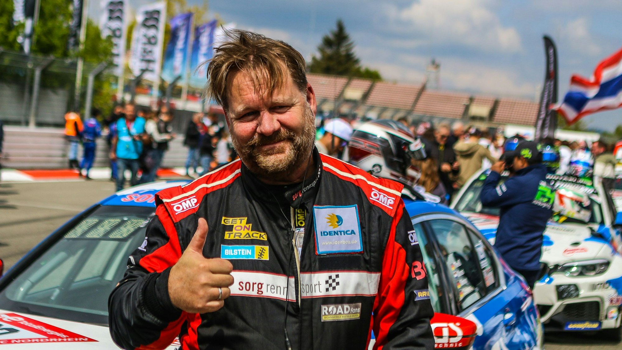 Das Bild zeigt den Rennfahrer Björn Simon, der den Daumen in die Höhe reckt.