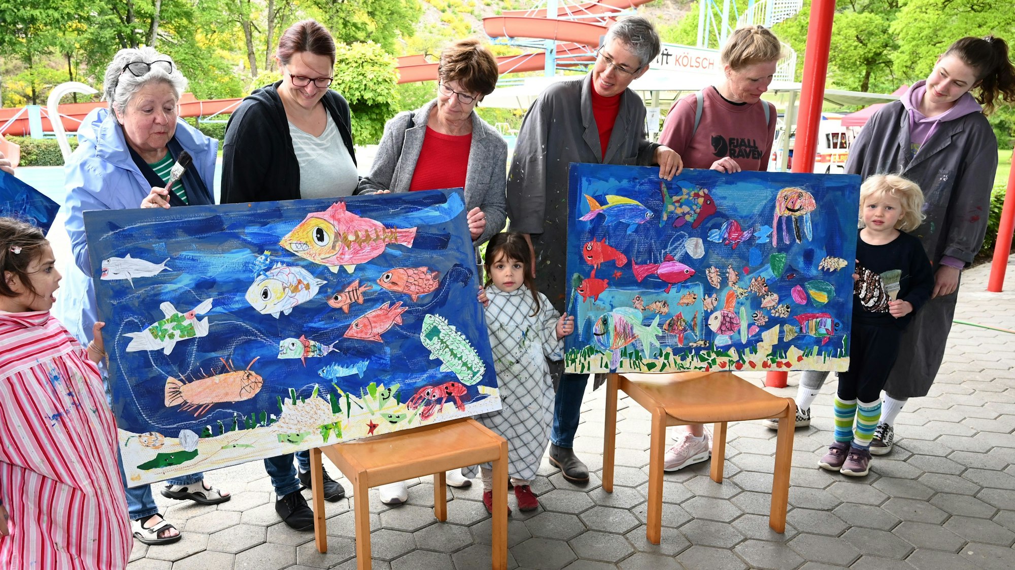 Kinder präsentieren ihre gemalten Bilder, die das Leben im Meer zeigen.